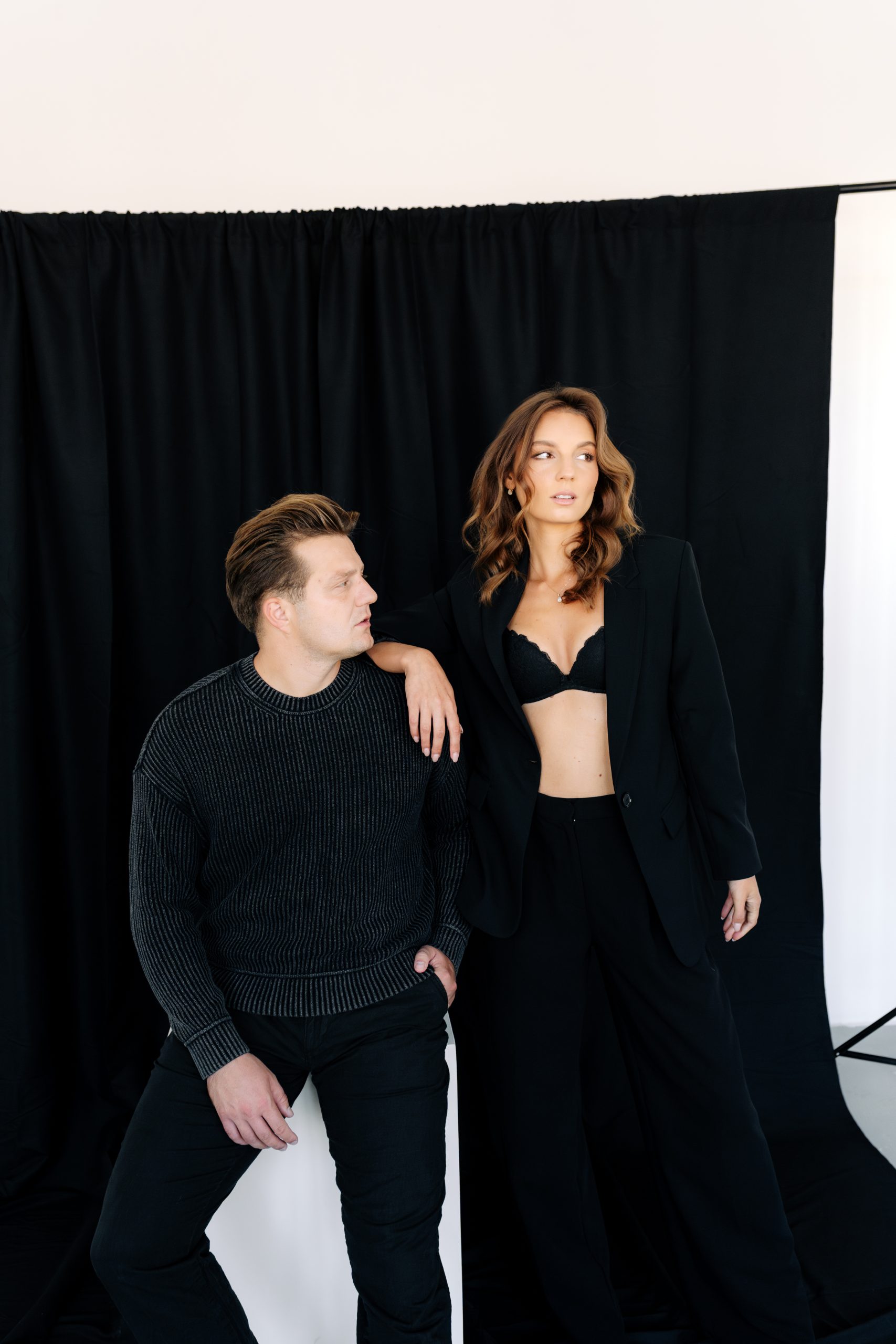 Párové focení v ateliéru HLight Studio. Elegantní portrét muže a ženy v černých outfitech s fashion atmosférou. Fotograf Lukáš Vavřinec zachytil stylizovanou a moderní podobu párové fotografie.