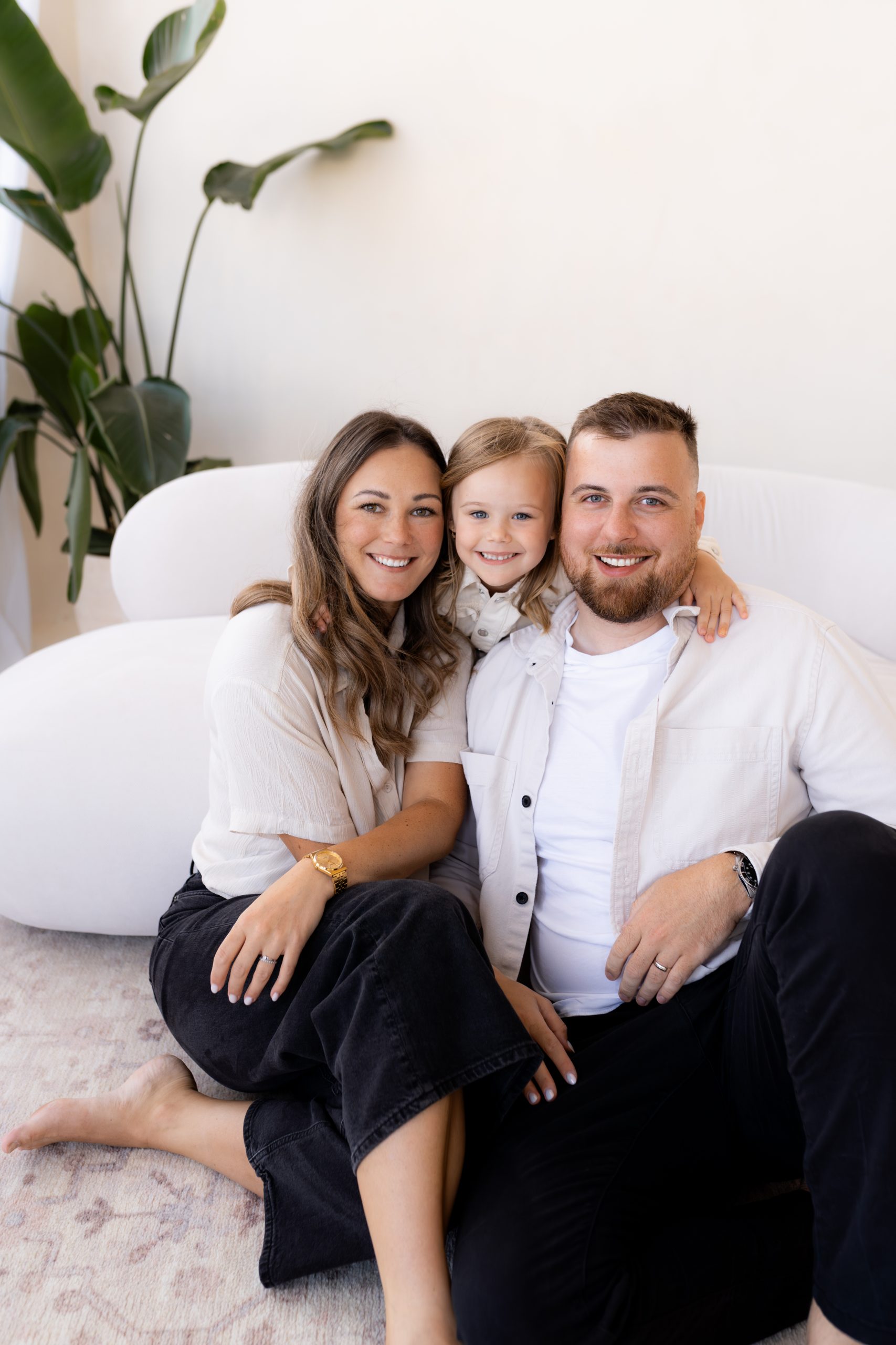 Rodinné focení v ateliéru HLight Studio – fotograf Lukáš Vavřinec zachytil usměvavou rodinu sedící společně na gauči.