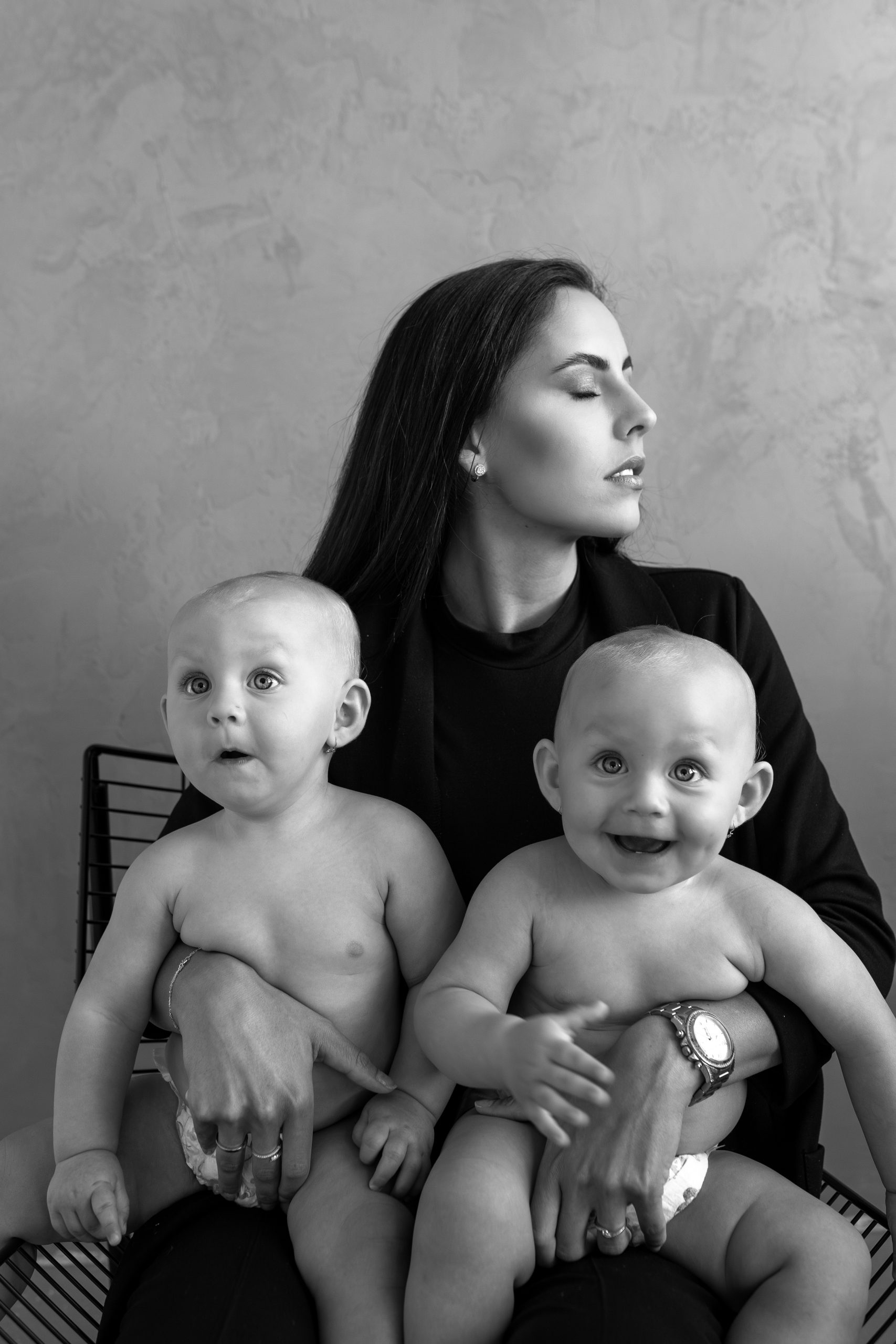 Černobílá fotografie maminky s dvojčaty pořízená v HLight Studio. Fotograf Lukáš Vavřinec zachytil jedinečný rodinný okamžik s důrazem na emoce a přirozenou krásu.