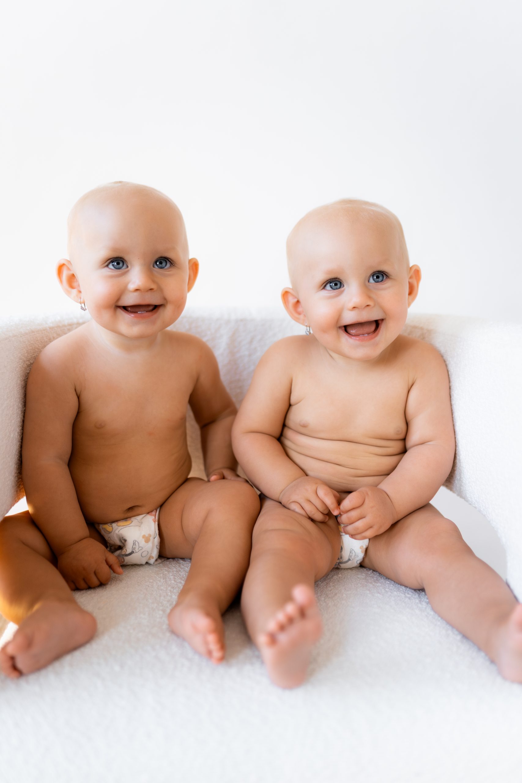 Portrétní fotografie usměvavých dvojčátek v ateliéru HLight Studio. Profesionální dětské focení od fotografa Lukáše Vavřince.