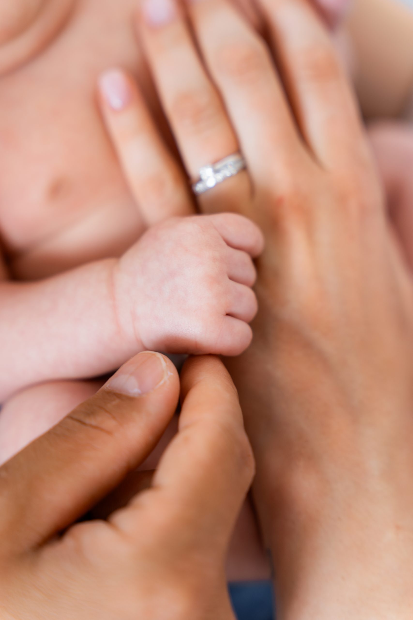 Detailní záběr dětské ručičky držící ruku rodiče. Fotografie plná něhy a symboliky lásky, foceno v HLight Studiu fotografem Lukášem Vavřincem.